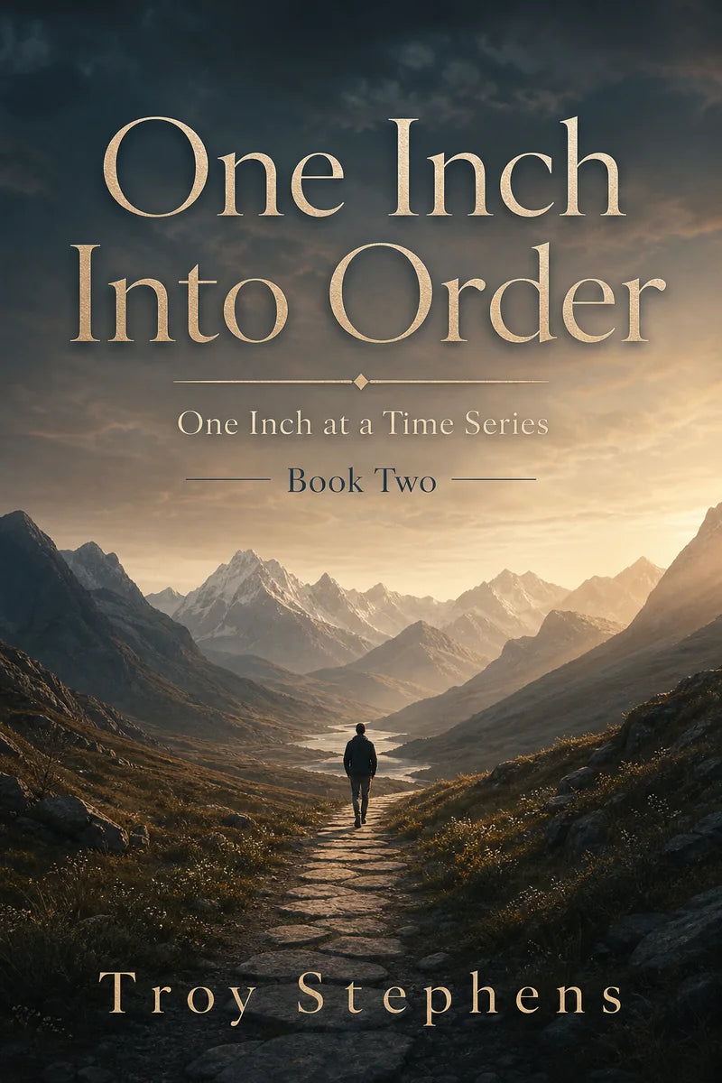 Cover of One Inch Into Order: a figure walks a stone path through a wide mountain valley in warm morning light.